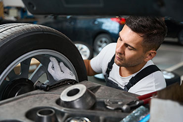Professional mechanic checking technical condition of a tire