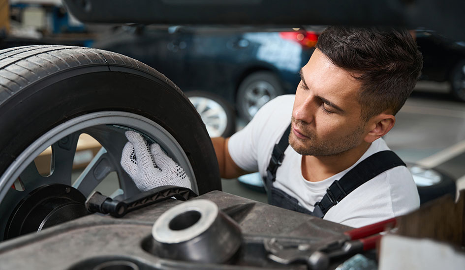 Professional mechanic checking technical condition of a tire